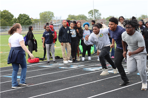 3 boys running in crowd of other people